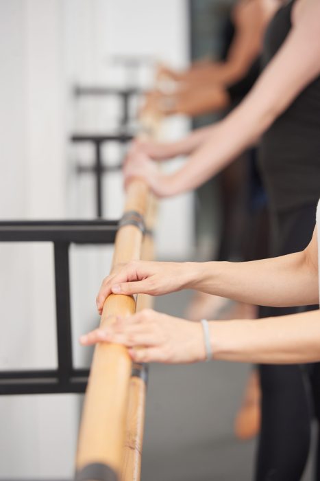 Practicing ballet Hands of ballet dancers on handrail, selective focus